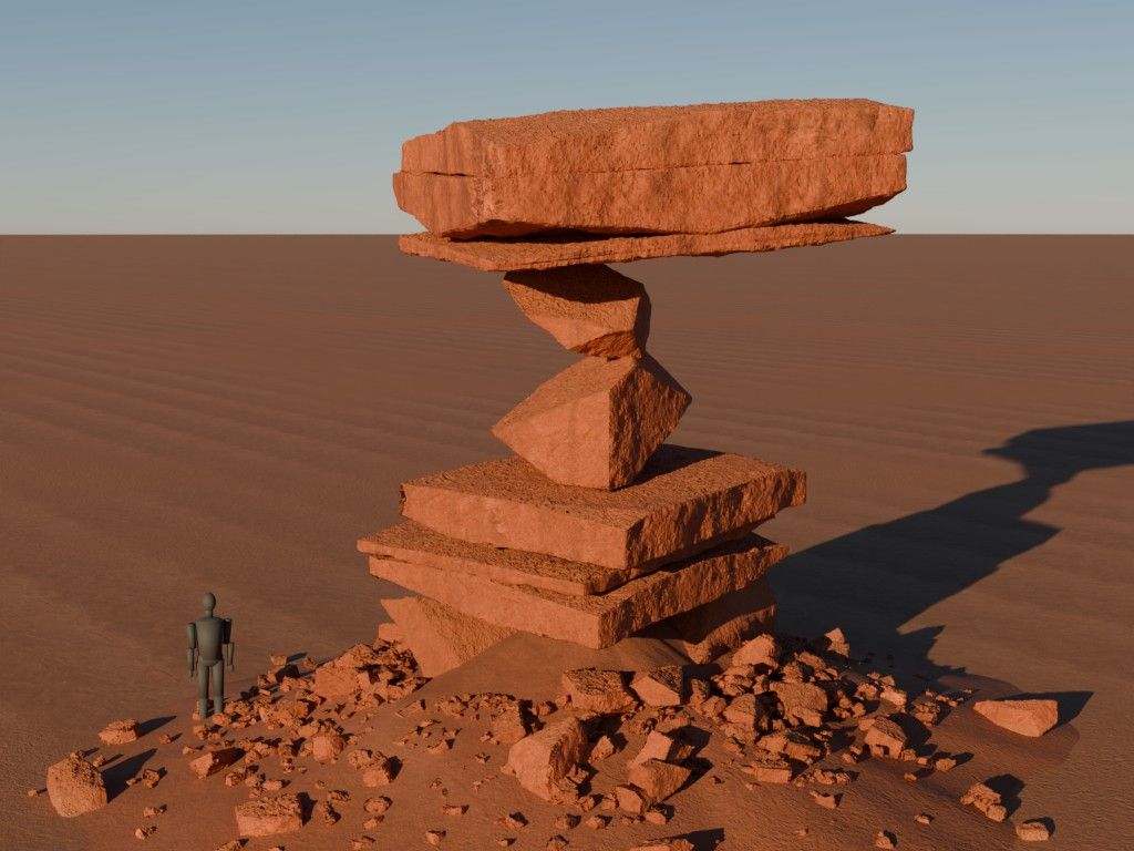 A balanced stack of red rock slabs above a rubble field